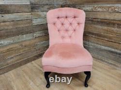Chaise de coiffeuse de chambre à coucher style régence vintage avec dossier boutonné et assise en rose.