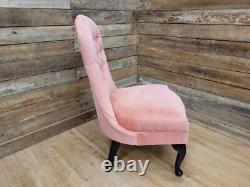 Chaise de coiffeuse de chambre à coucher style régence vintage avec dossier boutonné et assise en rose.