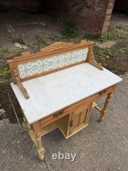 Meuble de salle de bains avec lavabo en pin antique et marbre carrelé à l'arrière