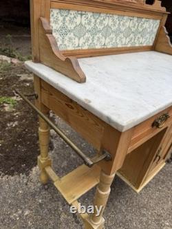 Meuble de salle de bains avec lavabo en pin antique et marbre carrelé à l'arrière