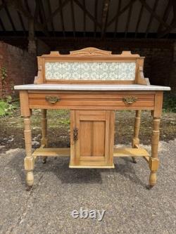 Meuble de salle de bains avec lavabo en pin antique et marbre carrelé à l'arrière