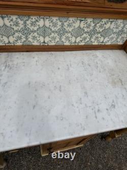 Meuble de salle de bains avec lavabo en pin antique et marbre carrelé à l'arrière
