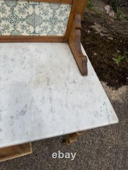 Meuble de salle de bains avec lavabo en pin antique et marbre carrelé à l'arrière