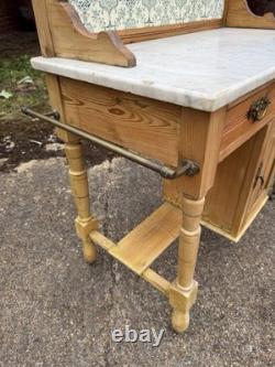 Meuble de salle de bains avec lavabo en pin antique et marbre carrelé à l'arrière